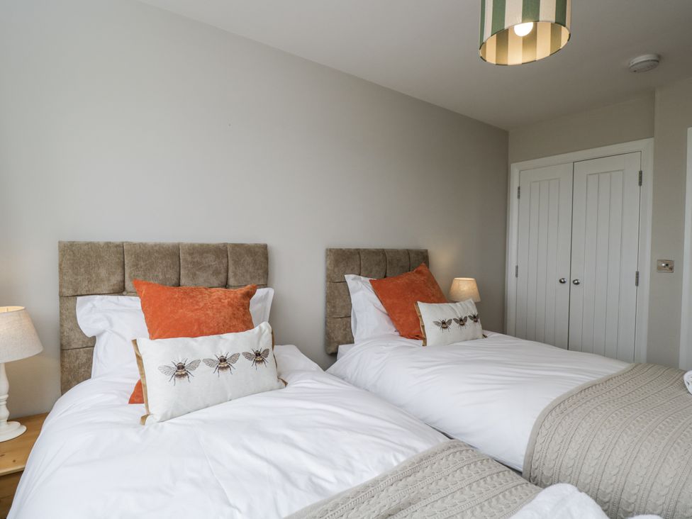A bedroom with two beds and a lamp at Hayloft
