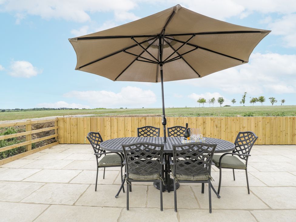 An outdoor dining area with a table and chairs under an umbrella at Hayloft 