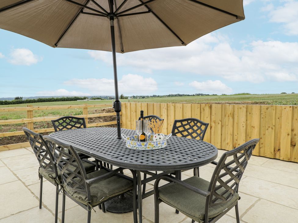 An outdoor dining area with a table and umbrellas at Hayloft
