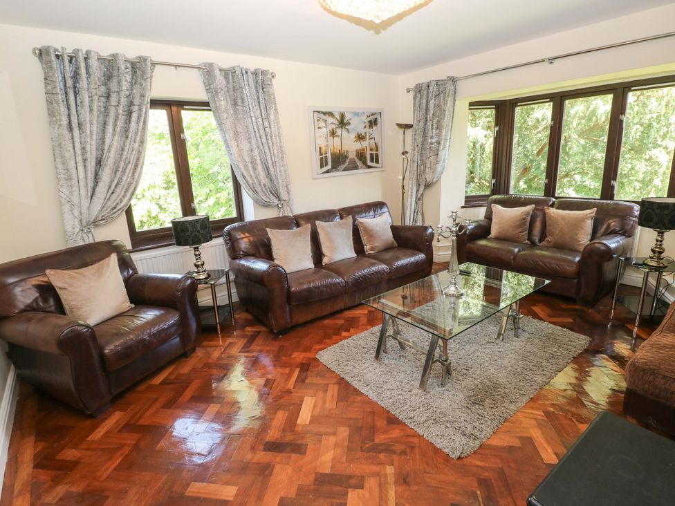 A living room with leather sofas and a coffee table at 170 Langland Road in Mumbles