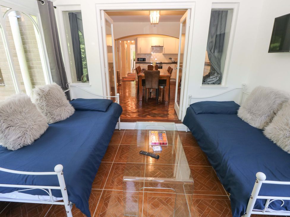 A snug with two sofa beds and a glass coffee table at 170 Langland Road Mumbles