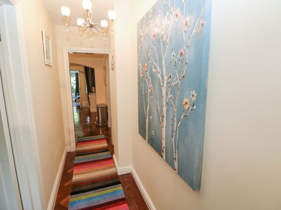 A hallway with a chandelier and artwork at 170 Langland Road Mumbles