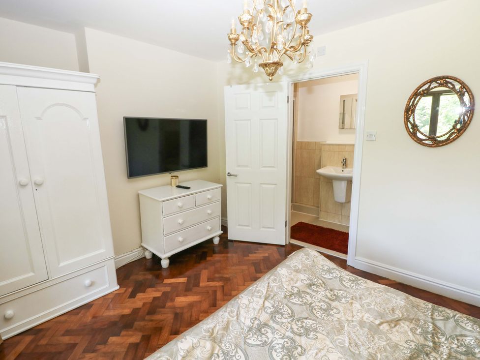 A bedroom with a wardrobe and a television at 170 Langland Road in Mumbles