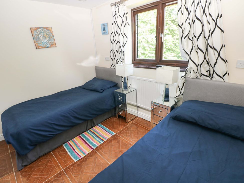 A bedroom with two beds and a window at 170 Langland Road Mumbles
