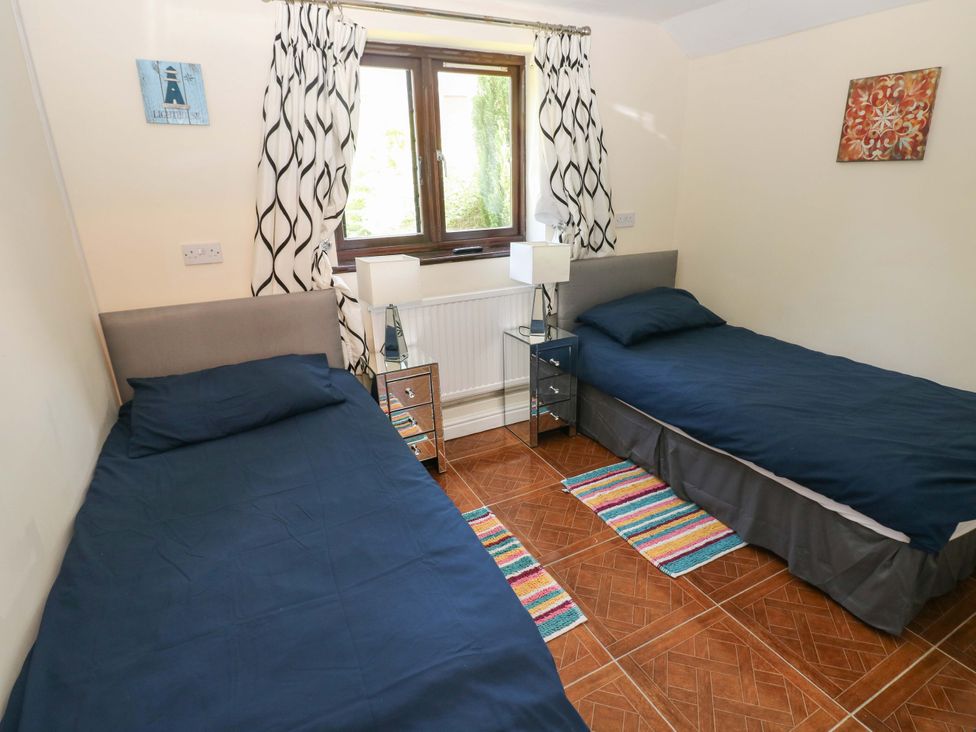 A bedroom with two beds and a window at 170 Langland Road Mumbles