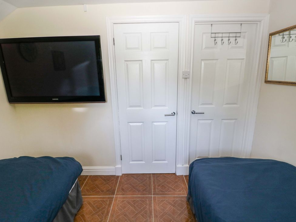 A bedroom with a TV and doors at 170 Langland Road Mumbles