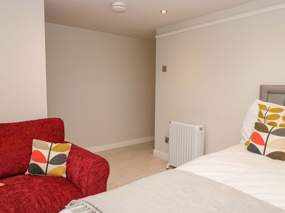 A bedroom with a sofa and bed at Poppy Cottage Bowness-On-Windermere