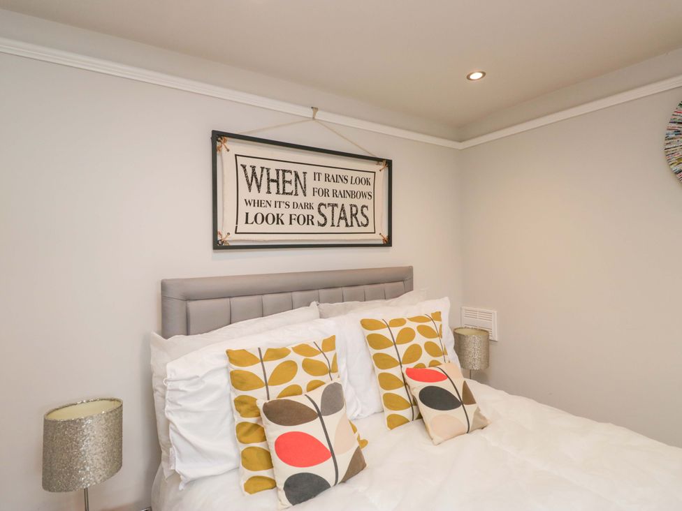 A bedroom with a bed and decorative pillows at Poppy Cottage in Bowness-On-Windermere