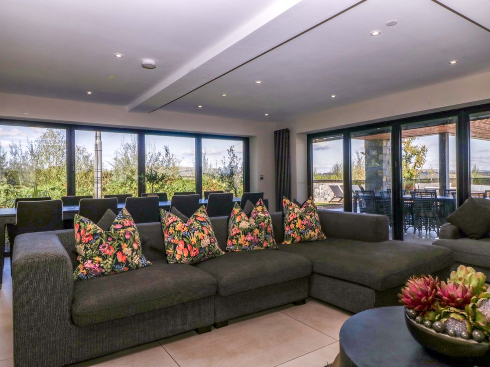 A living room with a sofa and cushions at Forest Lodge in Pontyclun