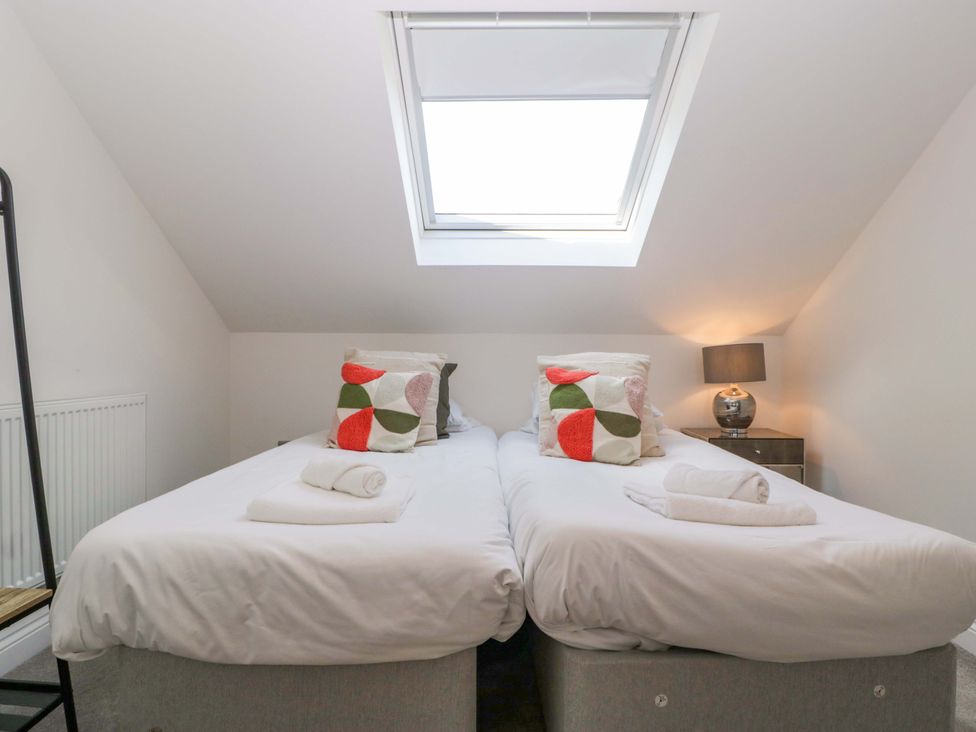 A bedroom with two beds and a lamp at Forest Lodge in Pontyclun