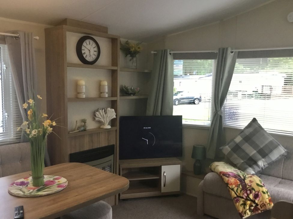 A living room with a television on a stand at 38 The Green