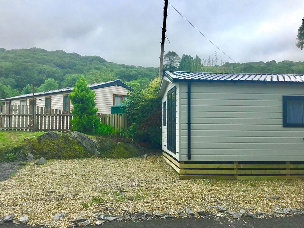 A cabin with a gravel area and trees at 38 The Green