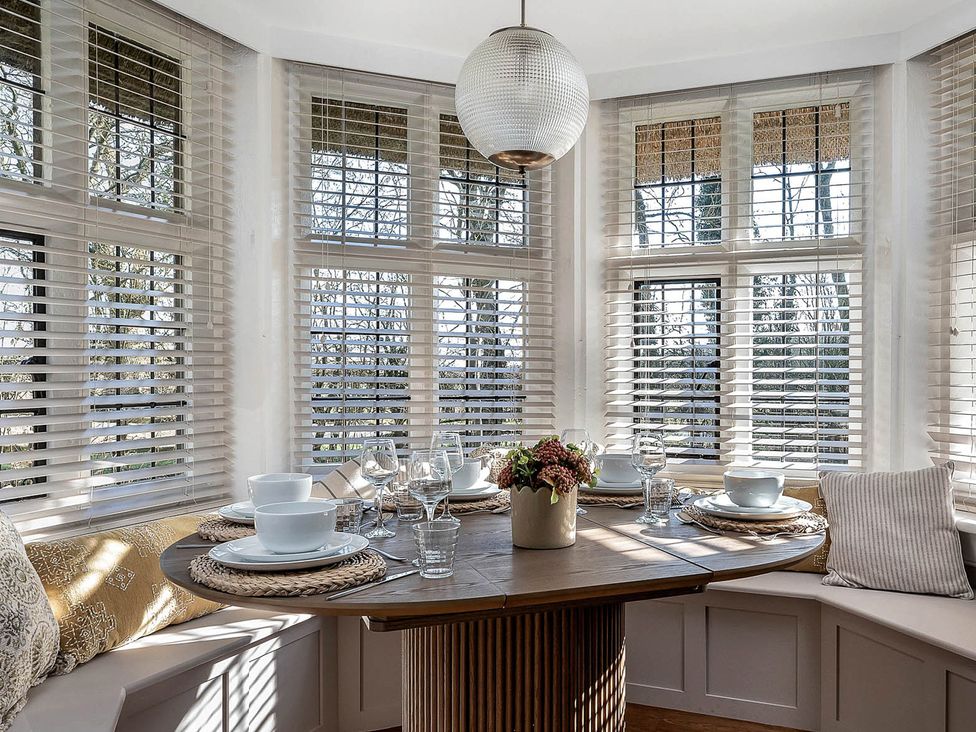A dining room with a round table and chairs at East Lodge in Peterborough