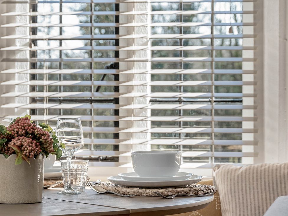 A dining table with flower pot and dishware at East Lodge in Peterborough