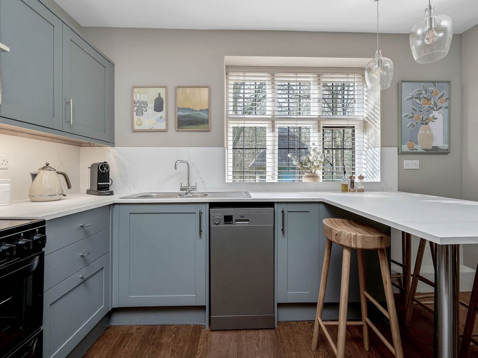 A kitchen with a sink, stove, dishwasher and a window at East Lodge in Peterborough