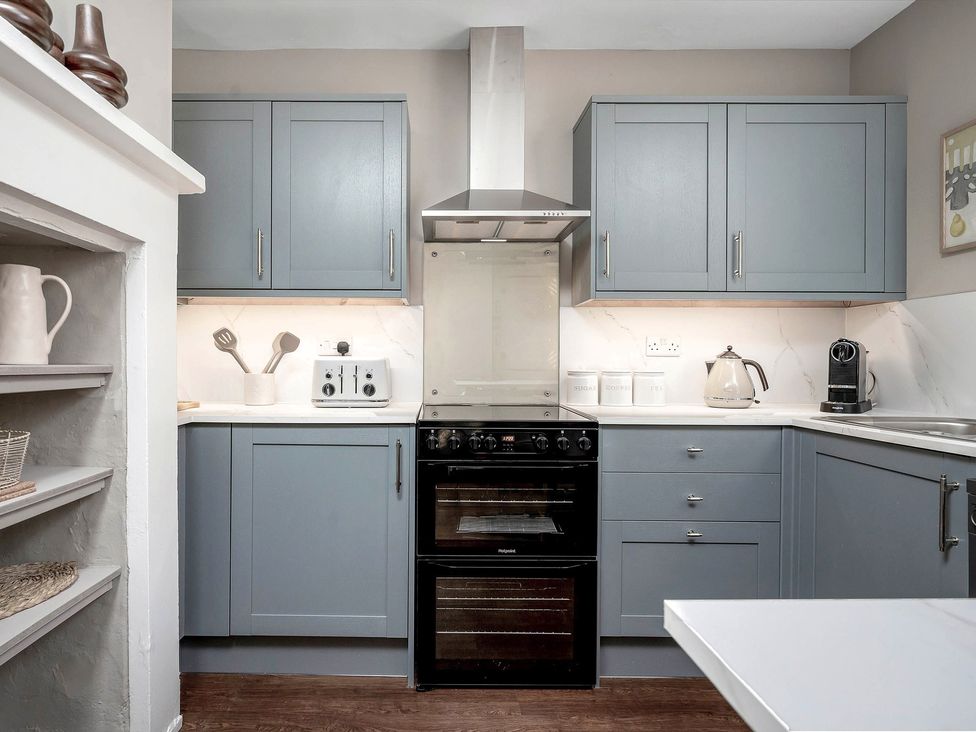 A kitchen with cabinets and appliances at East Lodge in Peterborough