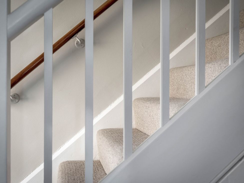 A staircase with a handrail and carpet at East Lodge in Peterborough