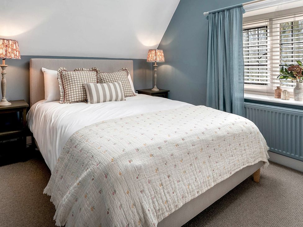 A bedroom with a bed and lamps at East Lodge in Peterborough