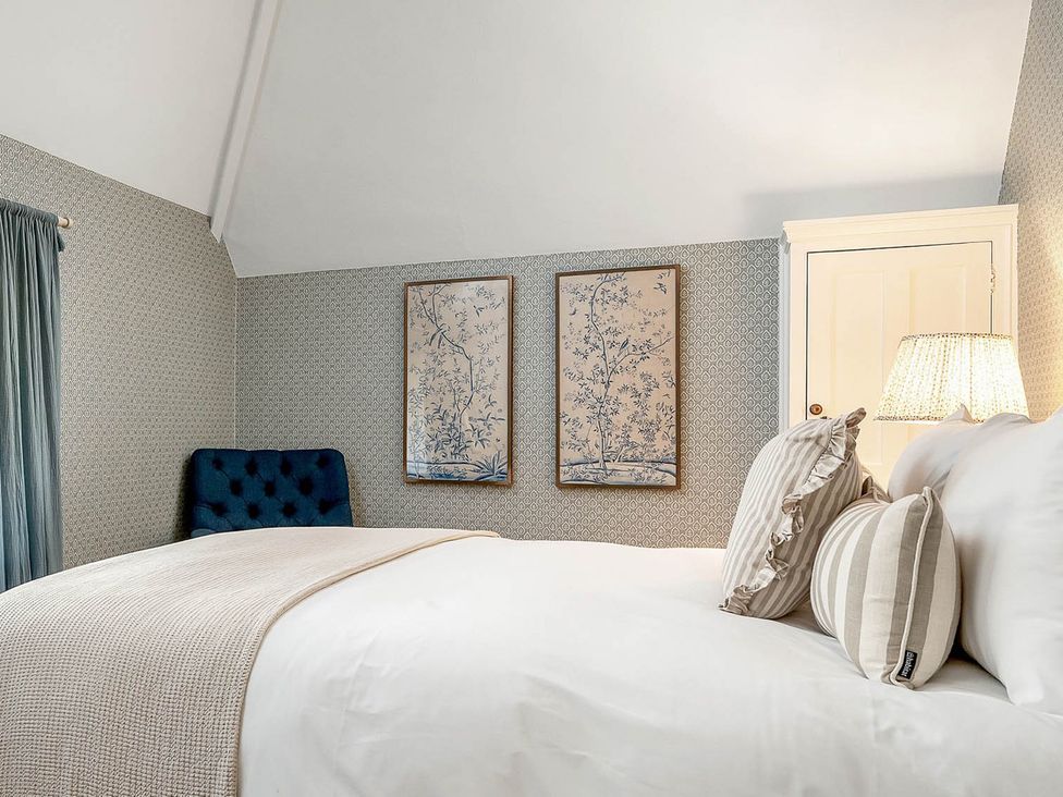 A bedroom with a bed and wall art at East Lodge in Peterborough