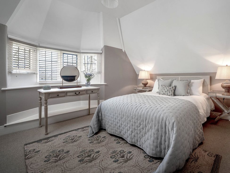 A bedroom with a bed and a desk at East Lodge in Peterborough