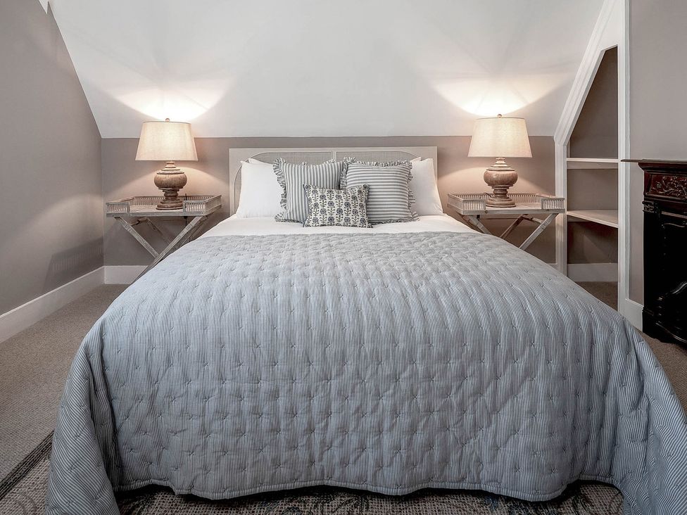 A bedroom with a bed and bedside tables at East Lodge in Peterborough