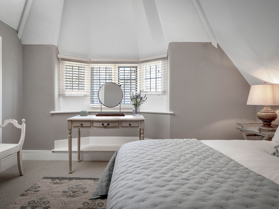 A bedroom with a bed and table at East Lodge in Peterborough