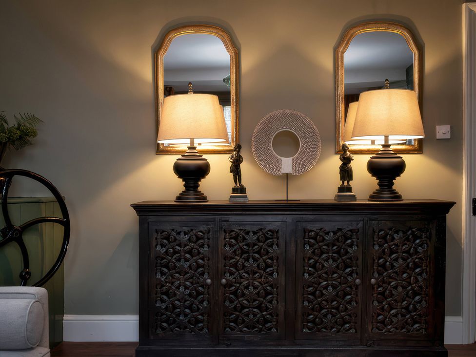 A living room with a console table and decorative items at The Gatehouse in Peterborough