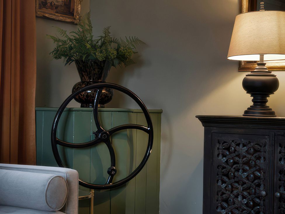 A living room with a steering wheel and a lamp at The Gatehouse in Peterborough