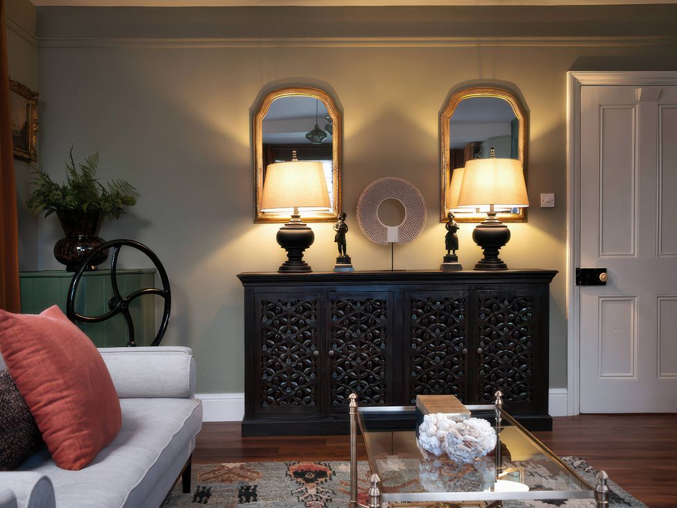 A living room with a console table and lamps at The Gatehouse in Peterborough