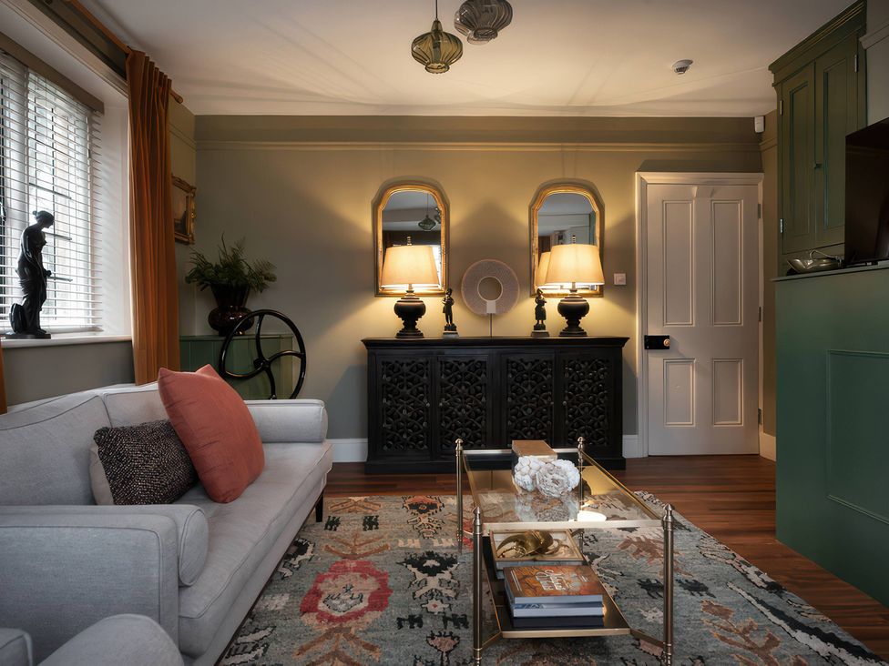 A living room with a sofa and coffee table at The Gatehouse in Peterborough