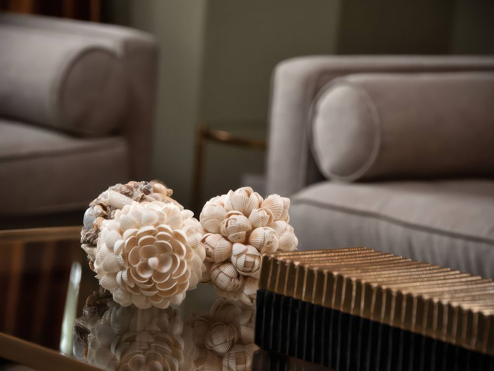 A living room with decorative shells on a table at The Gatehouse in Peterborough