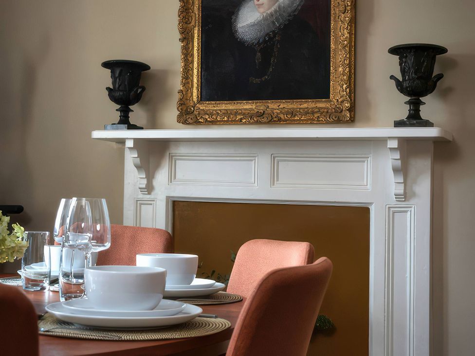 A dining room with a table set for a meal at The Gatehouse in Peterborough