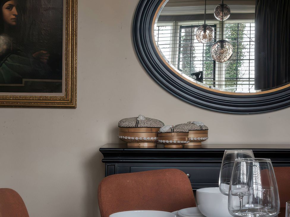 A dining room with a painting and decorative boxes at The Gatehouse in Peterborough