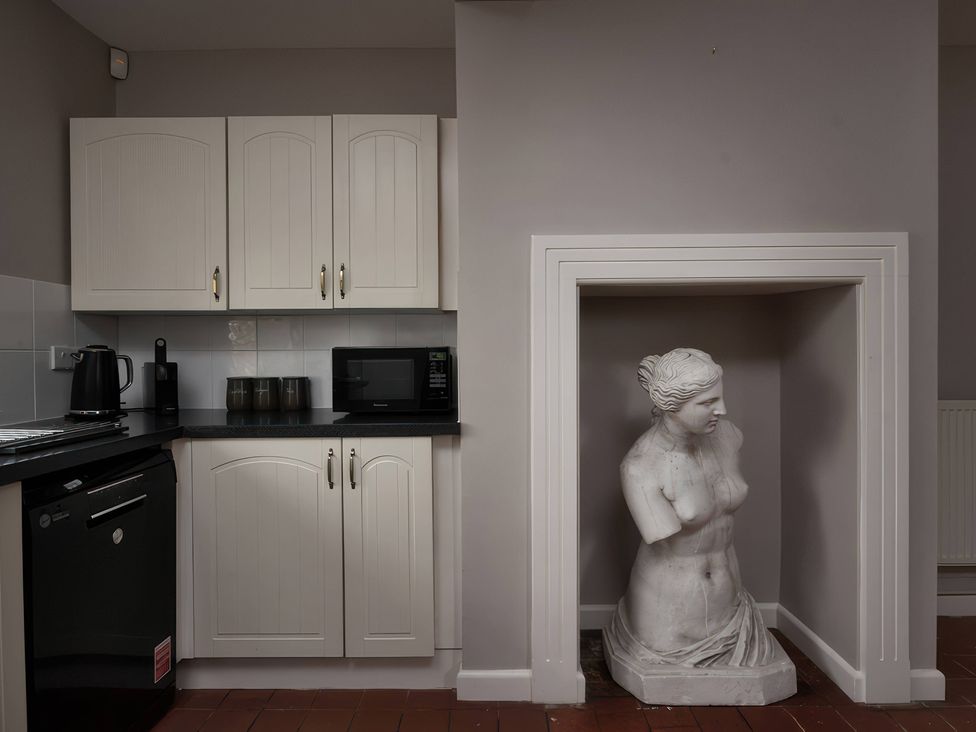 A kitchen with cabinets and a sculpture at The Gatehouse in Peterborough