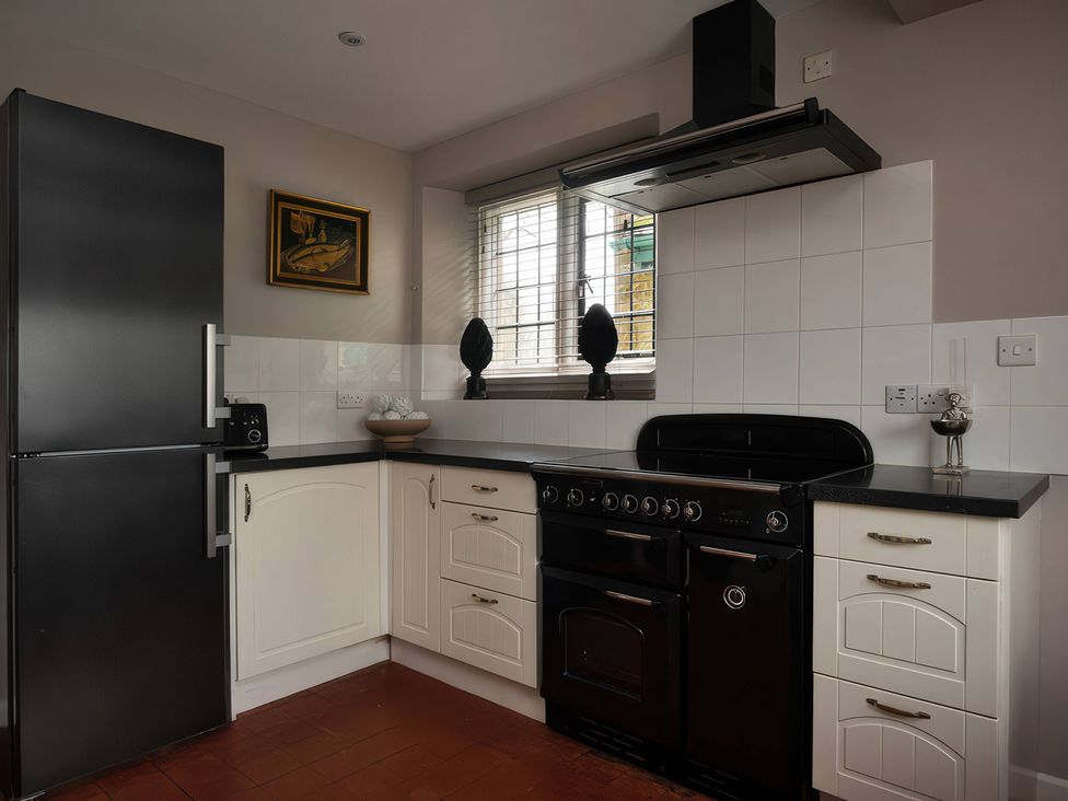 A kitchen with a refrigerator, stove, and cabinets at The Gatehouse in Peterborough