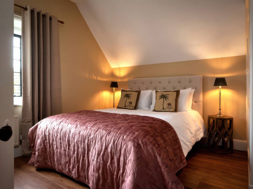A bedroom with a double bed and bedside lamps at The Gatehouse in Peterborough