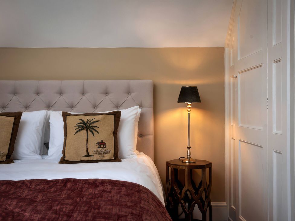 A bedroom with a bed and lamp at The Gatehouse in Peterborough