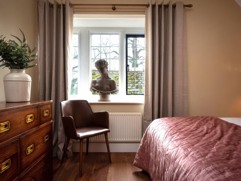 A bedroom with a bust on a windowsill at The Gatehouse in Peterborough