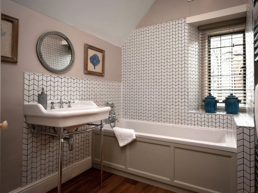 A bathroom with a bathtub and a sink at The Gatehouse in Peterborough