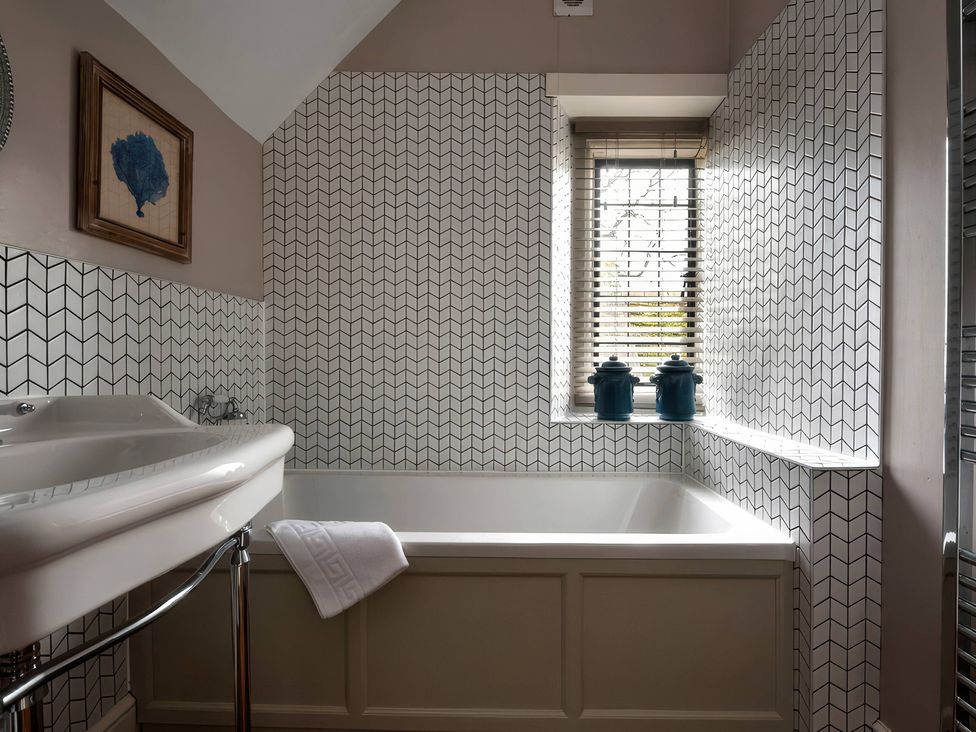 A bathroom with a bathtub and sink at The Gatehouse in Peterborough