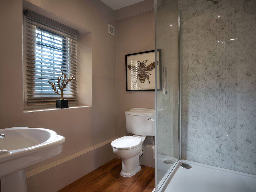 A bathroom with a sink, toilet, and shower at The Gatehouse in Peterborough