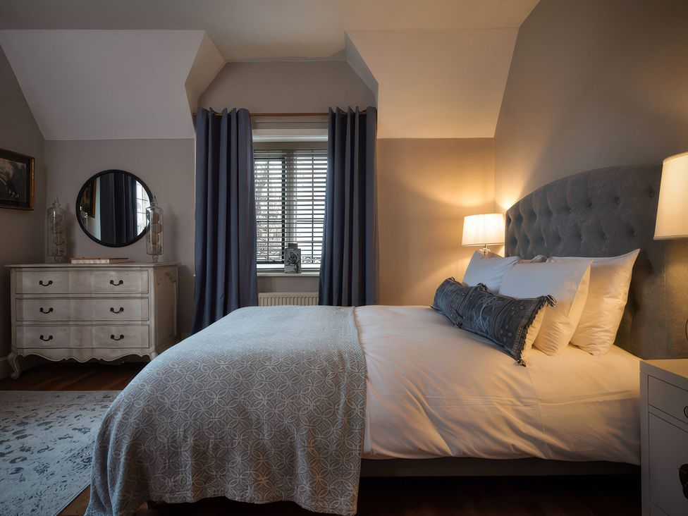 A bedroom with a bed and dresser at The Gatehouse in Peterborough