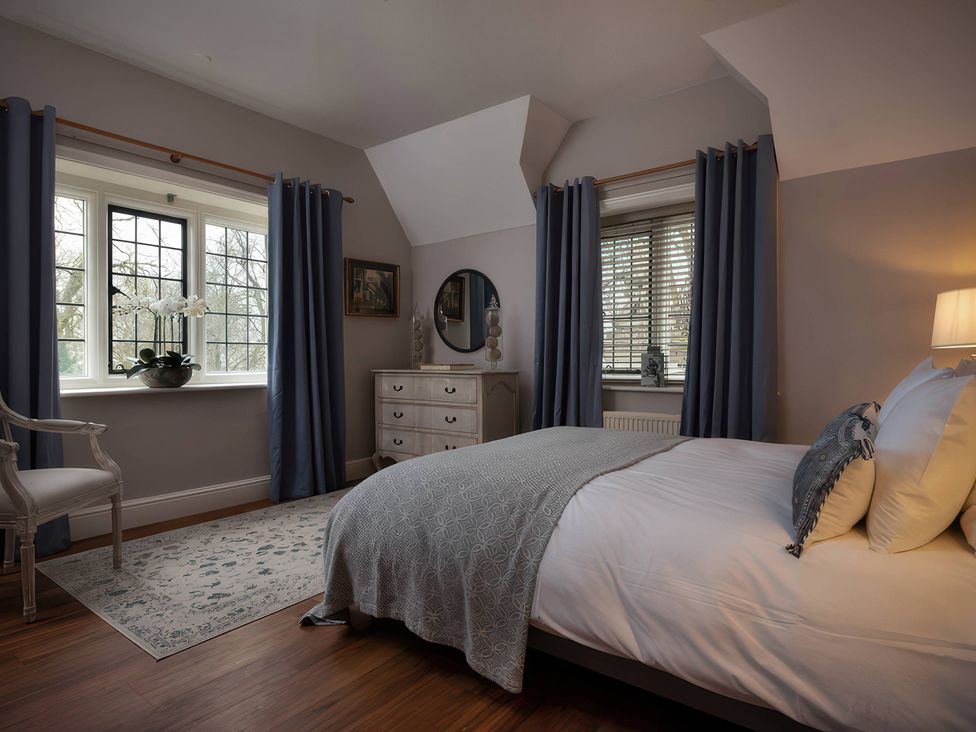 A bedroom with bed and dresser at The Gatehouse in Peterborough