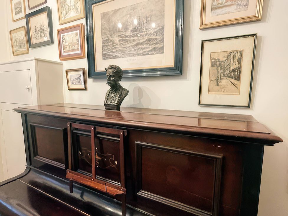 A furniture piece with a bust and framed art at Raphael Rooms in Peterborough