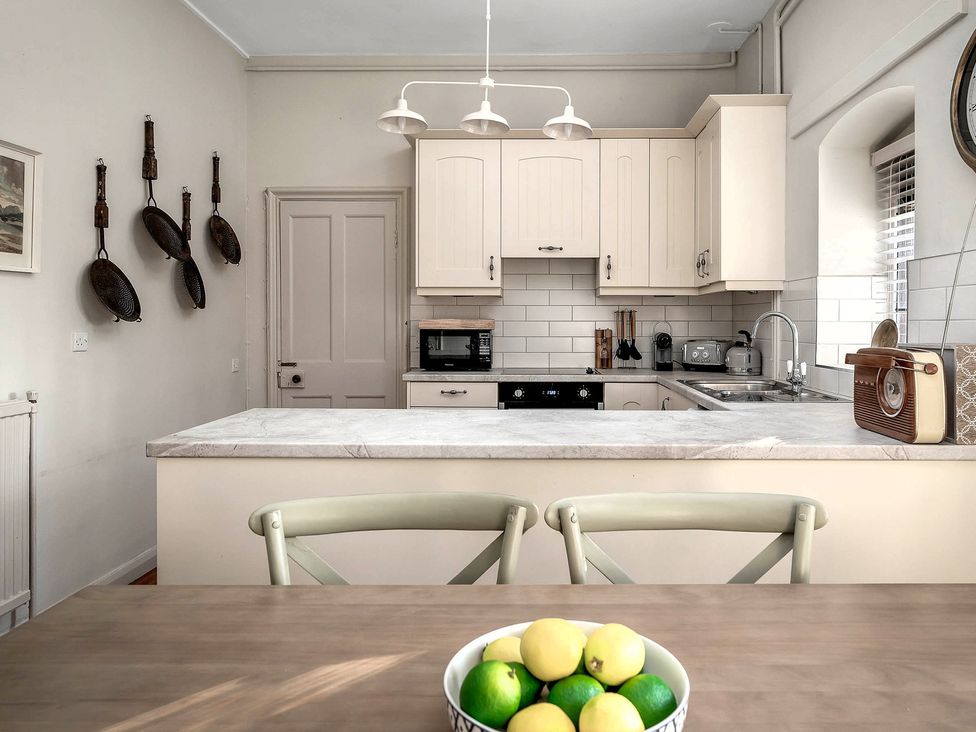 A kitchen with cabinets and a bowl of lemons on a table at Raphael Rooms in Peterborough