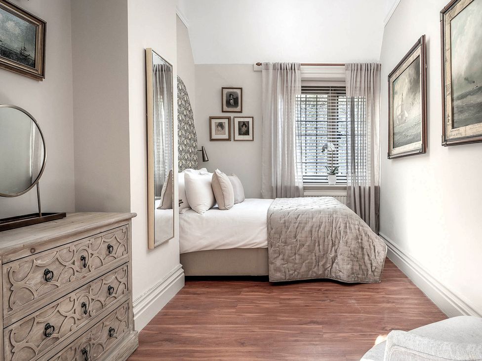 A bedroom with a bed and mirror at Raphael Rooms in Peterborough