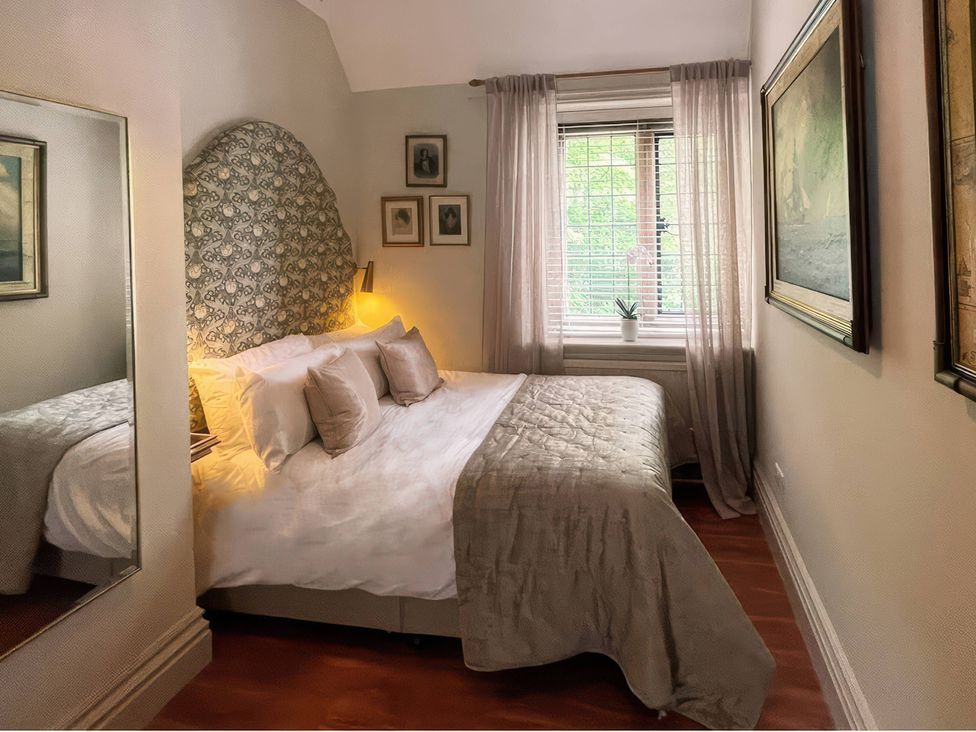 A bedroom with a bed and paintings at Raphael Rooms in Peterborough