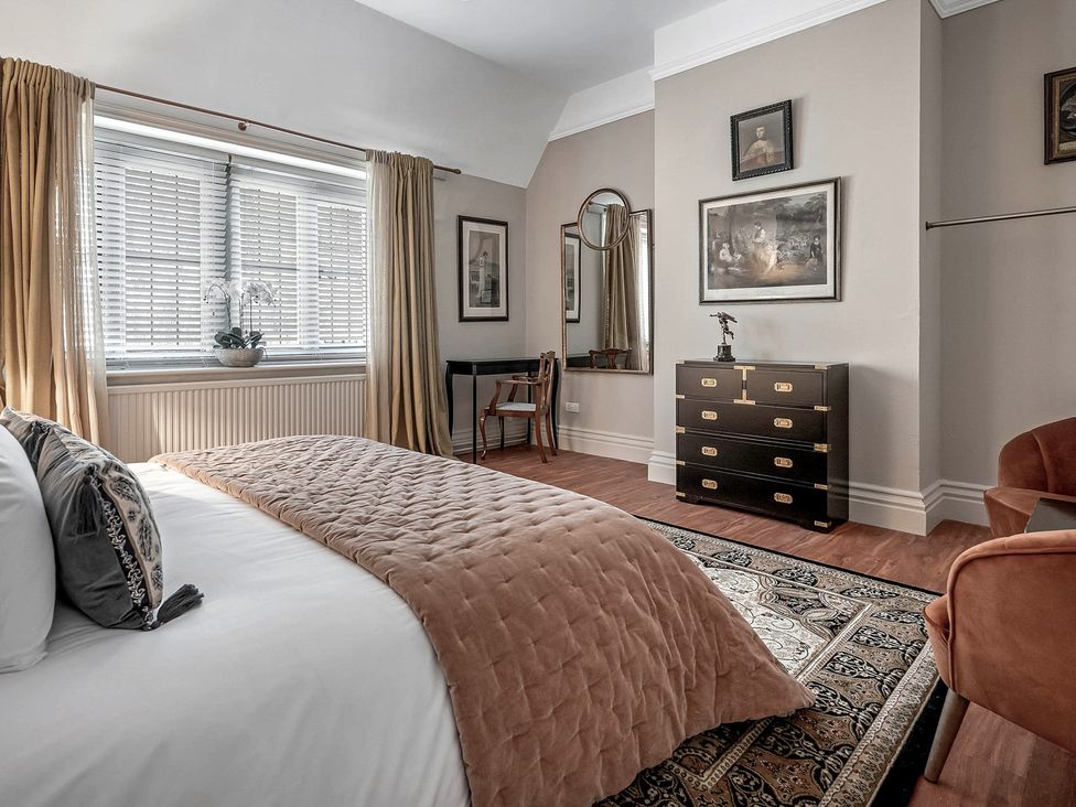 A bedroom with a bed and dresser at Raphael Rooms in Peterborough
