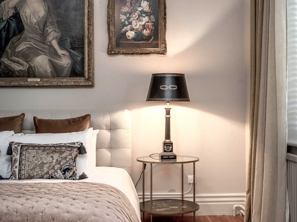 A bedroom with a bed and bedside table at Raphael Rooms in Peterborough