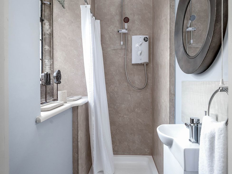 A bathroom with a shower and sink at Raphael Rooms Peterborough